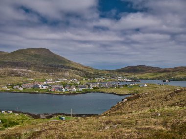İskoçya 'nın dış Hebrides bölgesindeki Barra adasındaki Castlebay köyü. Kuzeydoğuda Heaval Tepesi 'ne bakarken çekildi. Arka plandaki Barra' nın en yüksek noktası..