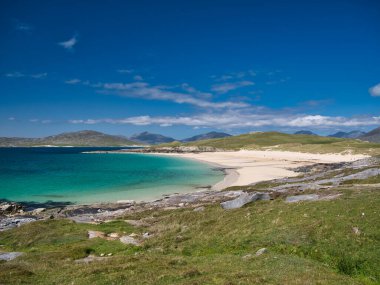 Outer Hebrides 'teki el değmemiş Luskentyre Körfezi' nin beyaz kumları ve turkuaz suları. Yazın güneşli bir günde çekilmiş..