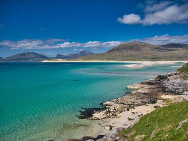 Outer Hebrides 'teki el değmemiş Luskentyre Körfezi' nin beyaz kumları ve turkuaz suları. Yazın güneşli bir günde çekilmiş..