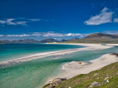 Outer Hebrides 'teki el değmemiş Luskentyre Körfezi' nin beyaz kumları ve turkuaz suları. Yazın güneşli bir günde çekilmiş..