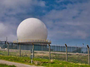 İskoçya 'nın Outer Hebrides kentinde bulunan Remote Radar Head (RH) Benbecula' daki beyaz radar kubbesi. RAF tarafından işletilen bir hava savunma radar istasyonu. İngiliz ASACS 'ının bir parçası..