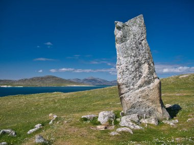 İskoçya 'nın başkenti Outer Hebrides' teki Harris Adası 'nın Atlantik kıyısındaki masanede bulunan 3 metre yüksekliğindeki MacLeod Taşı. Taransay adası arkada görülebilir..