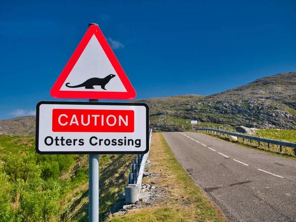 Road signs warning that otters may be crossing the road ahead. Taken at the bridge to the island of Scalpay in the Outer Hebrides, Scotland, UK on a sunny day with a blue sky