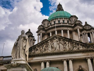 Belfast Belediye Binası 'nın önündeki Kraliçe Victoria heykeli. Fenerle kaplanmış 173 feet (53 m) yeşil bakır kubbe arka planda görünür..