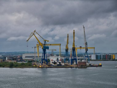 Kuzey İrlanda, İngiltere 'de Belfast Limanı' ndaki bir gemiyi turna kuşatıyordu. Arka planda Harland ve Wolff tersanesinin Samson ve Goliath vinçleri görünüyor..