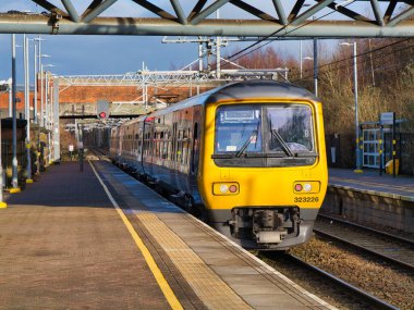 St Helens, İngiltere - 4 Ocak 2024: Liverpool 'dan Wigan Hattı' na Liverpool Lime Caddesi 'nden İngiltere' nin kuzeybatısındaki Wigan North Western 'e giden St. Helens Merkez İstasyonu' nda elektrikli bir banliyö treni.