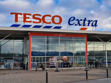 St Helens, İngiltere - 4 Ocak 2024: Kurumsal tabela ve St Helens, Merseyside, İngiltere 'deki bir Tesco Extra süpermarketinin müşteri girişi.