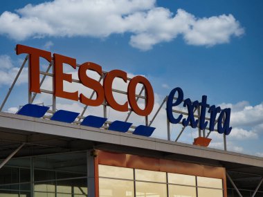 St Helens, İngiltere - 4 Ocak 2024: St Helens, Merseyside, İngiltere, İngiltere 'deki bir Tesco Extra süpermarketinde kurumsal tabela.