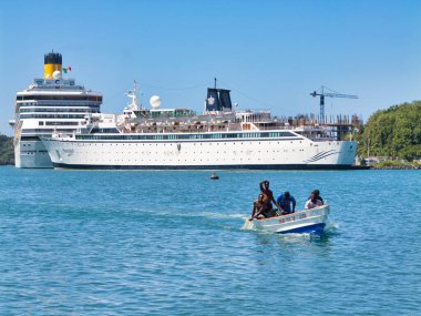 St. Lucia - 30 Ocak 2024: Buralı balıkçılar, arka planda Pointe Seraphine Cruise Limanı 'na demirlemiş yolcu gemileriyle Karayipler' deki St. Lucia 'daki Castries körfezindeki evlerine doğru yola çıktılar..