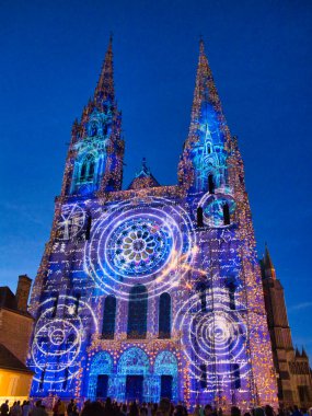 Chartres, Fransa - 10 Mayıs 2024: Fransa 'nın Centre-Val de Loire bölgesindeki Chartres Katedrali' nin ön cephesine bir lazer ışığı gösterisi yansıtıldı.
