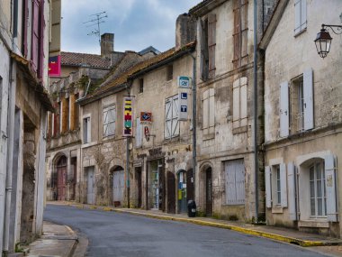 Bourdeilles, Fransa - 30 Nisan 2024: Fransa 'nın Dordogne bölgesindeki D78 yolunda, kapalı, kepenkli binalar ve ıssız bir sokak arasında bir Tabac açıldı.
