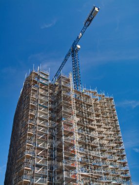 Malmö, İsveç - 27 Haziran 2024: İsveç 'in güneyinde Malmö' de modern, yüksek katlı bir binada inşaat çalışmaları. Yazın güneşli bir günde mavi gökyüzü ile çekildi..