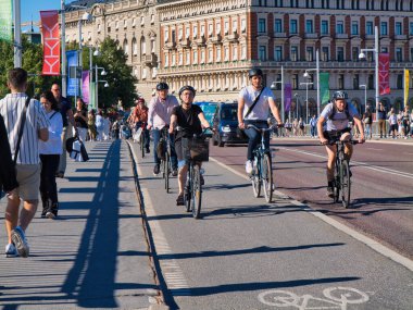 Stockholm, İsveç - 25 Haziran 2024 Stockholm şehir merkezinde bisiklet yolunda bisikletçiler. Yazın güneşli bir günde çekilmiş..