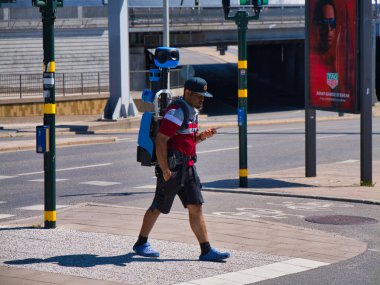 Stockholm, İsveç - 26 Haziran 2024: Google Maps markalı sırt çantası kamera teknolojili bir yaya Stockholm, İsveç 'te yürürken elde tutulan bir cihaza danışıyor.