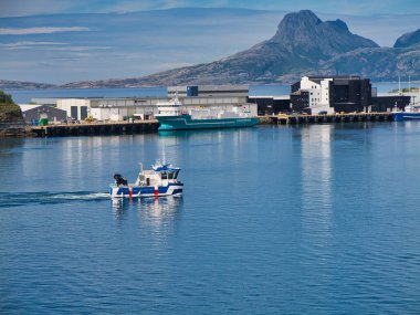 Bodo, Norveç - 18 Haziran 2024: Norveç 'teki Bodo Limanı' ndan geçen bir GMV servis botu. Güneşli ve sakin bir günde çekildi. Aqua Lady, genel bir kargo gemisi, arka planda görünüyor..
