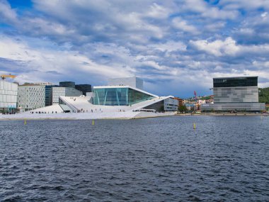 Oslo, Norveç - 12 Haziran 2024: Oslo Opera Evi - Norveç Ulusal Opera ve Balesi 'nin ve Norveç' teki ulusal opera binasının evi. Munch Müzesi sağda..