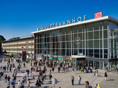Köln, Almanya - 8 Haziran 2024: Köln 'ün dışındaki turist ve banliyö kalabalığı - Koln Merkez Tren İstasyonu - Güneşli bir yaz gününde mavi gökyüzü ile Hauptbahnhof.