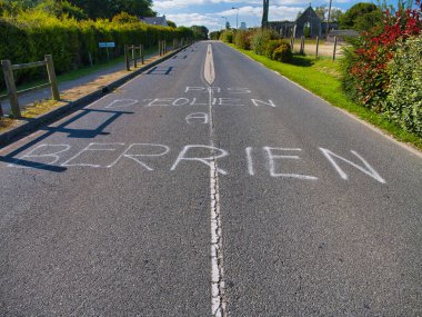 Berrien, France - Sep 17 2024: A protest about wind turbines spray painted onto a road in Berrien, Brittany in northern France. clipart