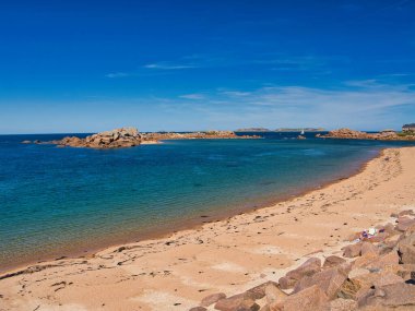Perros-Guirec, Lannion, İngiltere 'nin Ploumanac' h yakınlarındaki ünlü Pembe Granit Sahili 'nde kaya oluşumları. Yazın güneşli bir günde çekildi, mavi gökyüzü ve ışık bulutu ile.