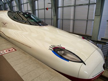 Japonya 'nın Kyushu adasındaki yüksek hızlı tren istasyonunda modern demiryolu teknolojisi ve tasarımı sergilenen parlak bir Shinkansen ön görüntüsü..