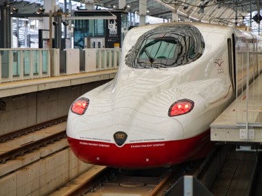 Japonya 'nın Kyushu adasındaki yüksek hızlı tren istasyonunda modern demiryolu teknolojisi ve tasarımı sergilenen parlak bir Shinkansen ön görüntüsü..