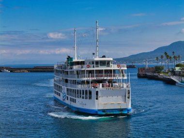 Kagoshima, Kyushu, Japonya 'daki Sakurajima feribotu, açık bir günde kıyı şeridi ve uzak dağların manzaralı manzarasıyla denize açılır..