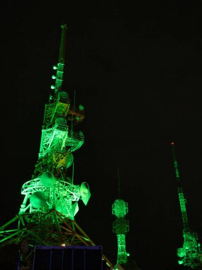 Inasa Dağı, Nagasaki Dağı, Kyushu, Japonya 'daki iletişim kuleleri gece aydınlandı. Yeşil ışıklar karanlık gökyüzüne karşı karmaşık yapıları vurgular..
