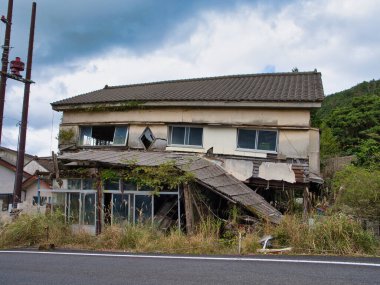 Japonya 'nın orta kesimindeki Kyushu' da yıkık dökük çatılı, depremden zarar görmüş terk edilmiş ev, yapısal yıkım ve aşırı gelişmiş bitki örtüsü sergiliyor..