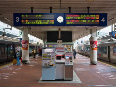 Fukuoka, Kyushu, Japonya 'daki Hakata İstasyonu' nda bekleyen yolcular, JR trenleri iki dilli dijital kalkış panoları ve otomatların altında 3 ve 4 numaralı platformlarda bekliyor..