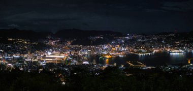 Inasa Dağı 'ndan çekilen Nagasaki şehrinin panoramik manzarası geceleri gökyüzü ve limanı gösteriyor..