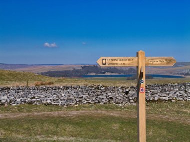 İngiltere, Yorkshire Dales yakınlarındaki Pennine Bridleway tabelasında, manzaralı kırsal ve ulusal park manzaraları boyunca yürüyüş ve bisiklet rotaları işaretlenmektedir..
