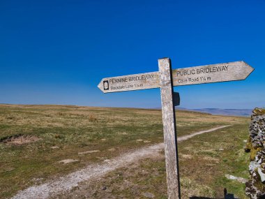 İngiltere, Yorkshire Dales yakınlarındaki Pennine Bridleway tabelasında, manzaralı kırsal ve ulusal park manzaraları boyunca yürüyüş ve bisiklet rotaları işaretlenmektedir..