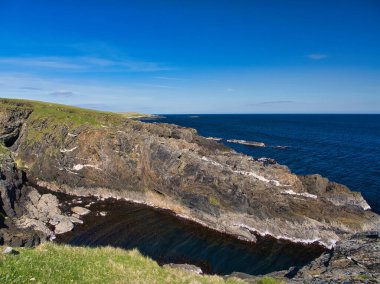 Çarpıcı beyaz kaya katmanlarıyla engebeli uçurumlar, İngiltere 'nin Shetland, Ramnageo Ness' inde engin denizle buluşuyor.. 