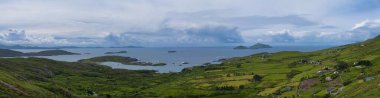 Irelands 'ın Atlantik kıyısına geniş bir bakış açısı, çarpıcı bir gökyüzü altında yemyeşil manzaralar ve dağınık adalar..