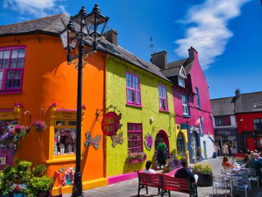 Kinsale, İrlanda - 28 Mayıs 2025: Kinsale, İrlanda 'daki canlı mağazalar ve evler parlak mavi gökyüzü altında canlı ve neşeli bir atmosfer yaratıyor.