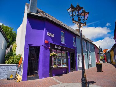 Kinsale, İrlanda - 28 Mayıs 2025: Canlı mor ve pastel renkli binalar Kinsale, İrlanda 'da canlı mavi bir gökyüzünün altında ilginç bir cadde çiziyor..