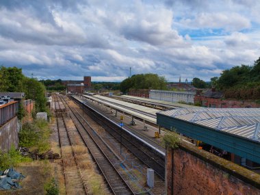 Shrewsbury, İngiltere - Aug 07 2025: Şropshire, İngiltere 'deki Shrewsbury tren istasyonundaki platformların ve rayların geniş görünümü, dramatik öğleden sonra bulutları altında.