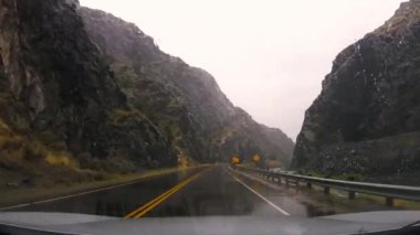 Yağmurlu bir günde, Wyoming yakınlarındaki Rüzgâr Nehri Kanyonu 'nda cam sileceği sesleriyle tünelden geçiyorum.