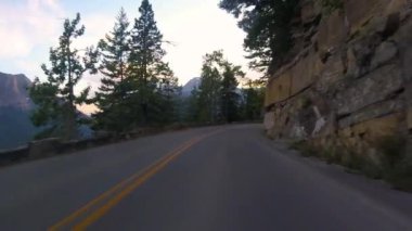 Yaz aylarında Montana 'daki Buzul Ulusal Parkı' nda güneşin batışına doğru sürüş.