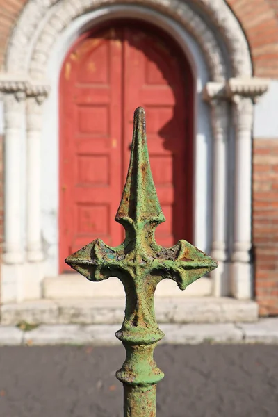 Cross shaped metal ornament of the fence of the church