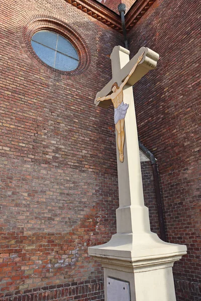 教会のレンガの壁の前の十字架上のイエス キリスト像 — ストック写真