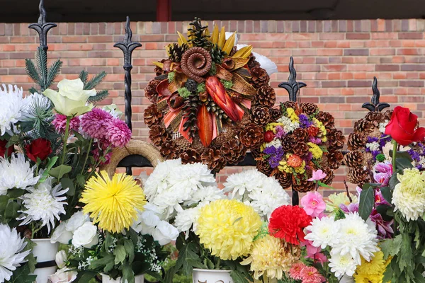 Flowers and wreaths on a fence in the public cemetery