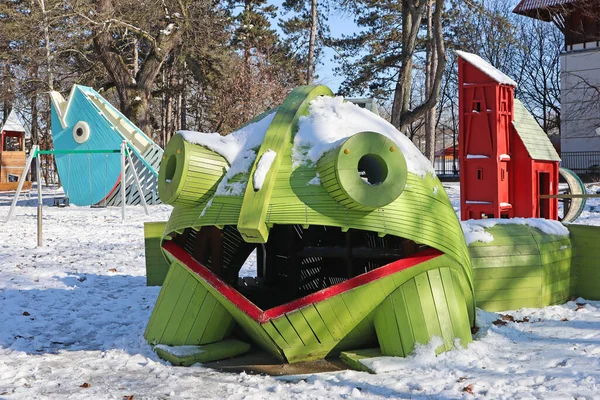 Giant frog toy at the playground in winter time