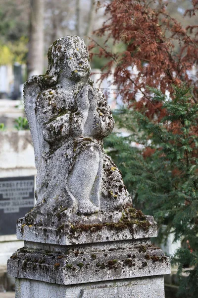 Angel figurine statue on a grave in the public cemetery
