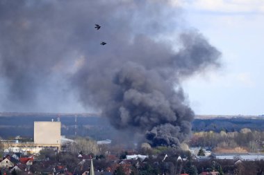 Şehrin üzerinde büyük yangın ve duman var.