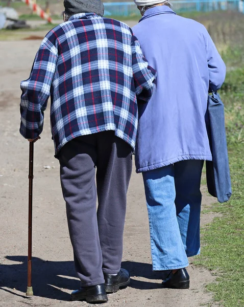老夫婦が未舗装の道を歩く — ストック写真