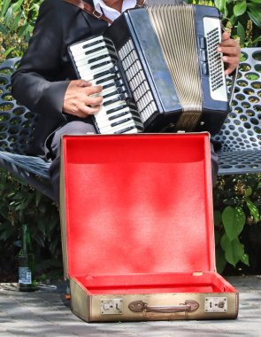 Ahenkli adam şehir sokaklarında akordeon çalıyor.
