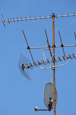 Mavi gökyüzüne karşı parabolik ve televizyon antenleri