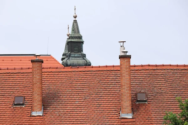 背後に教会の塔のある屋根の上に煙が積もっている — ストック写真