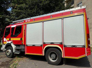 Şehirdeki bir apartmanın yanındaki itfaiye aracı.